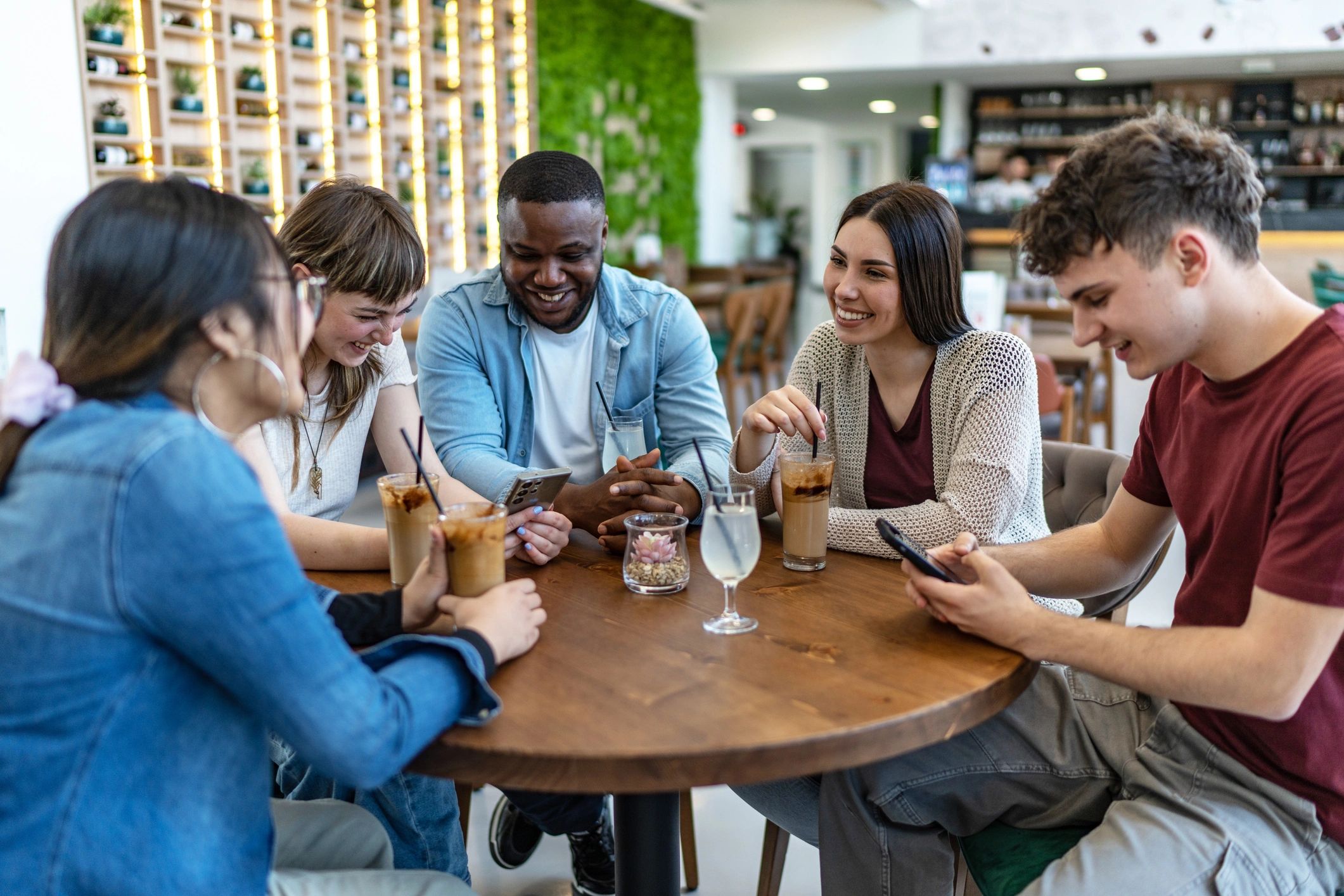 Team collaborating around a phone reviewing social content